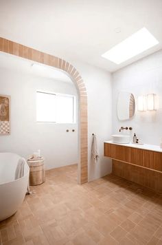 a bathroom with a large tub, sink and mirror in it's center wall