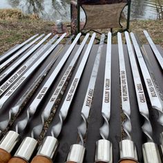 there are many spoons that are on the picnic table near some water and trees