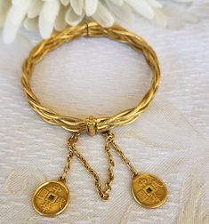 This is a gorgeous 22K ( stamped) braided bracelet with textured and high polished strands.  This hinged bangle style bracelet features a screw down hinge clasp with safety chain.  Suspended from the chain are 2 decorative Chinese coins.  Gross weight 59 grams. Size 6 1/2, 8.50 mm in width.  This bracelet is hand wrought.  Pieces like this bracelet were traditionally used as part of a dowry.  Look closely at the photos for they are also part of the description.  Ask questions.  We are happy to answer any questions you may have.   An appraisal has been done on this piece and it is available upon request. Keep in mind our items are preowned, vintage or antique and may show signs of wear and use. ALL SALES FINAL. NO RETURNS OR EXCHANGES. PLEASE ASK ALL QUESTIONS AHEAD OF TIME. *All pictures h Bangles Style, Braided Bracelet, Wedding Jewelry Bracelets, Gold Hand, Safety Chain, Hinged Bracelet, Gold Hands, Hinged Bangle, Bracelet Gold