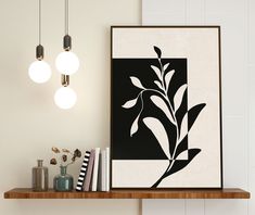 a black and white art print on a shelf next to some books, candles and other items