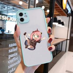 a person holding up a phone case with an anime character on it