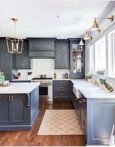 a kitchen with gray cabinets and white counter tops