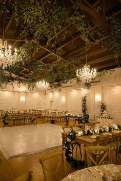 a large room with tables, chairs and chandeliers