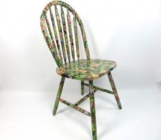 a wooden chair with floral designs on it's back legs and seat, against a white background