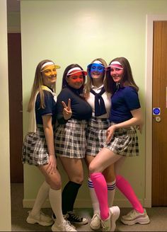 four girls in school uniforms posing for the camera with their faces painted like they're friends