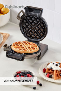 the waffle maker is sitting next to some berries and yogurt on plates