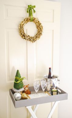 a table with wine glasses and a wreath on the wall above it, along with other items