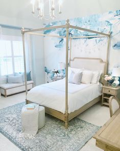 a bedroom with a canopy bed and chandelier hanging from it's ceiling