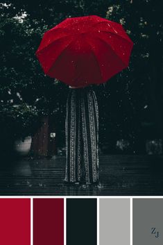 a person holding an umbrella in the rain with red and black colors to match them