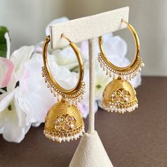 "A stunning pair of designer gold polki jhumka hoop earrings. These mesmerizing gold-plated jhumka hoops are the perfect way to add a touch of fashionable glamour to your look. The unique design includes carved polki detailing and intricate beading that highlights the hoops' curved etching. These beauties will leave a lasting impression. Length 2.5\" | Width 1.5\" Items are carefully packed and ready for gifting. All pictures are taken in natural light please allow for slight variations in color Festive Heavy Temple Jewelry Hoop Earrings, Temple Jewelry Style Hoop Earrings With Cutdana, Gold Dangle Chandbalis With Cutdana, Kundan Hoop Earrings With Intricate Design For Diwali, Round Hoop Earrings With Meenakari For Diwali, Intricate Kundan Hoop Earrings For Diwali, Heavy Festive Hoop Earrings, Bollywood Style Round Hoop Earrings With Meenakari, Temple Jewelry Style Meenakari Hoop Earrings For Diwali