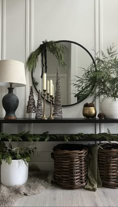 a shelf with baskets and candles on top of it next to a mirror that says, christmas