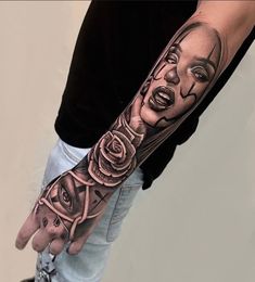 a man with a tattoo on his arm and hand is holding a rose in front of him