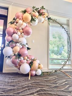 a balloon arch is decorated with pink, white and gold balloons in the shape of a crescent