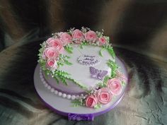 a cake decorated with pink roses and butterflies