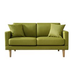 a green couch with two pillows on it's back and one pillow in the middle