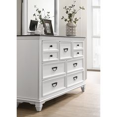 a white dresser with drawers and a mirror