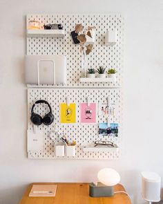 a wooden table with headphones on top of it next to a wall mounted shelf