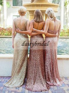 three women standing in front of a fountain with their back to the camera and looking at something