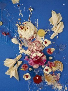 an arrangement of food on a blue surface with white and red icing sprinkles