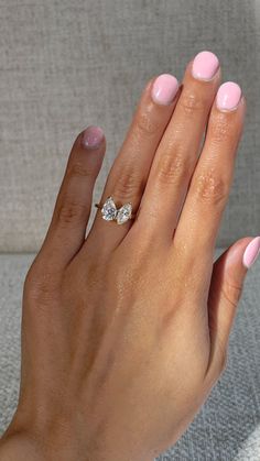 a woman's hand with pink manicures and a diamond ring