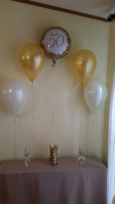 some balloons are on a table near a clock