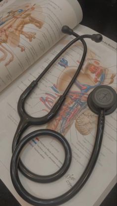 a stethoscope sitting on top of an open book next to medical diagrams