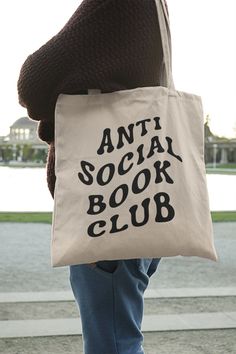 a person holding a book bag with the words anti social book club printed on it