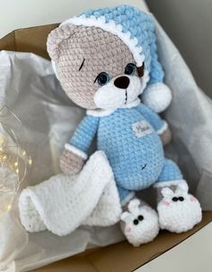 a crocheted teddy bear sitting in a box