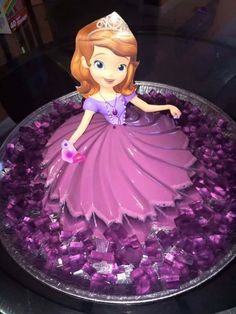 there is a cake made to look like a princess in purple dress and tiara