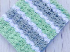 a green and white crocheted dishcloth sitting on top of a wooden table