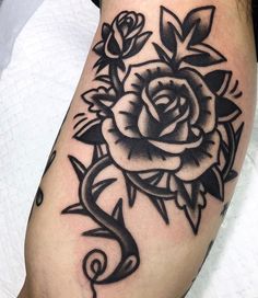 a black and white rose tattoo on the leg