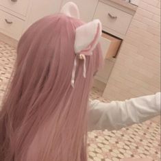 a woman with long pink hair in a bathroom