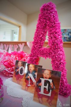 a table topped with pink tissue flowers and letters that spell out the word love on it