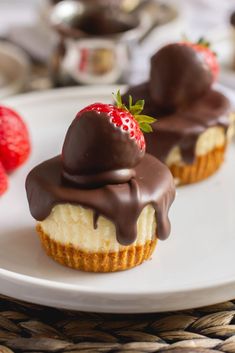 two desserts with chocolate and strawberries on a white plate next to some strawberries