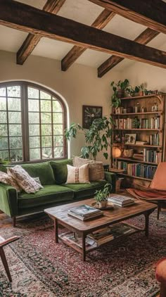 a living room filled with furniture and a large window covered in bookshelves next to a green couch