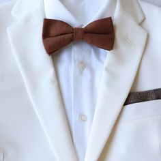 Color:  Brown Material:  Cotton                                                                                                                                                       Adult Pre-Tied Bow Tie:  approx. 4.75 inches wide and 2.5 inches height.  Neck strap is adjustable from 11.5 inches to 20 inches with metal hook for secure and comfortable wear. Child Pre-Tied Bow Tie: approx. 4 inch width and 2 inch length Neck size 11 inches - 19 inches Plastic clasp for each wear and removal. Dapper White Adjustable Suit And Tie Accessories, Classic Adjustable Suit And Tie Accessories For Groom, Classic Adjustable Suit Accessories For Groom, Adjustable Bow Tie For Business, White Bow Tie For Business Occasion, Classic Adjustable Tie For Groom, Classic Adjustable Ties For Groom, Classic Groom Suit And Tie Accessories, Classic Groom's Suit And Tie Accessories