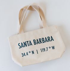 High quality 15 oz canvas tote crafted in the USA. Screen-printed with our original Santa Barbara latitude and longitude coordinates design. 10”w x 7”h x 3”d Personalized Cotton Canvas Travel Bag, Personalized Cotton Canvas Bag For Travel, Personalized Eco-friendly Canvas Travel Bag, Eco-friendly Personalized Canvas Travel Bag, Eco-friendly Personalized Canvas Bag For Travel, Latitude And Longitude, Santa Barbara, 7 H, Canvas Tote