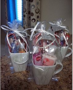 two white mugs filled with candy and candies