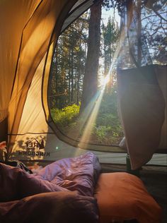 the inside of a tent with sunlight coming through it and trees in the back ground