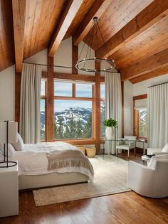 a bedroom with wooden ceilings and white furniture