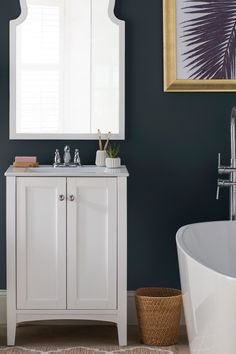 a bathroom with a sink, mirror and bathtub in the corner next to a painting