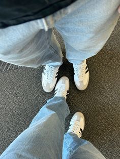 a person standing on the floor wearing white sneakers