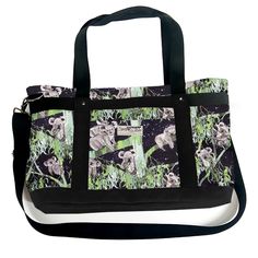 a black and white bag with an image of koalas in the grass on it