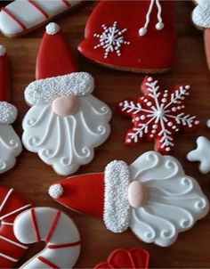 christmas cookies decorated like santa claus and snowflakes on a table with candy canes