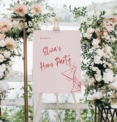 an easel with a sign and flowers on it