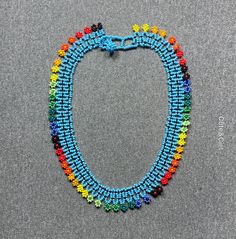 This beautiful beaded necklace is hand-woven by the women of the Embera Chami Indigenous Tribe of Colombia Handwoven Beaded Bracelets With Round Beads, Blue Handwoven Necklaces With Round Beads, Unique Blue Handwoven Beaded Necklaces, Handwoven Blue Beaded Necklaces, Unique Handwoven Blue Beaded Necklaces, Blue Handwoven Beaded Necklace, Unique Handwoven Blue Beaded Necklace, Fair Trade Unique Beaded Necklaces, Handwoven Blue Beaded Necklaces For Festivals