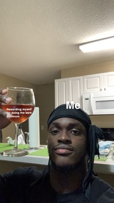 a man holding up a wine glass with the caption me