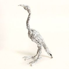 a metal bird is standing on its hind legs and it's head turned to the side