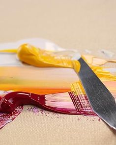 a knife and some paint on a table