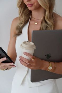 a woman holding a coffee cup and tablet